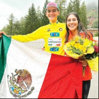 Isaac del Toro y Andrea Flores muestran una bandera mexicana.